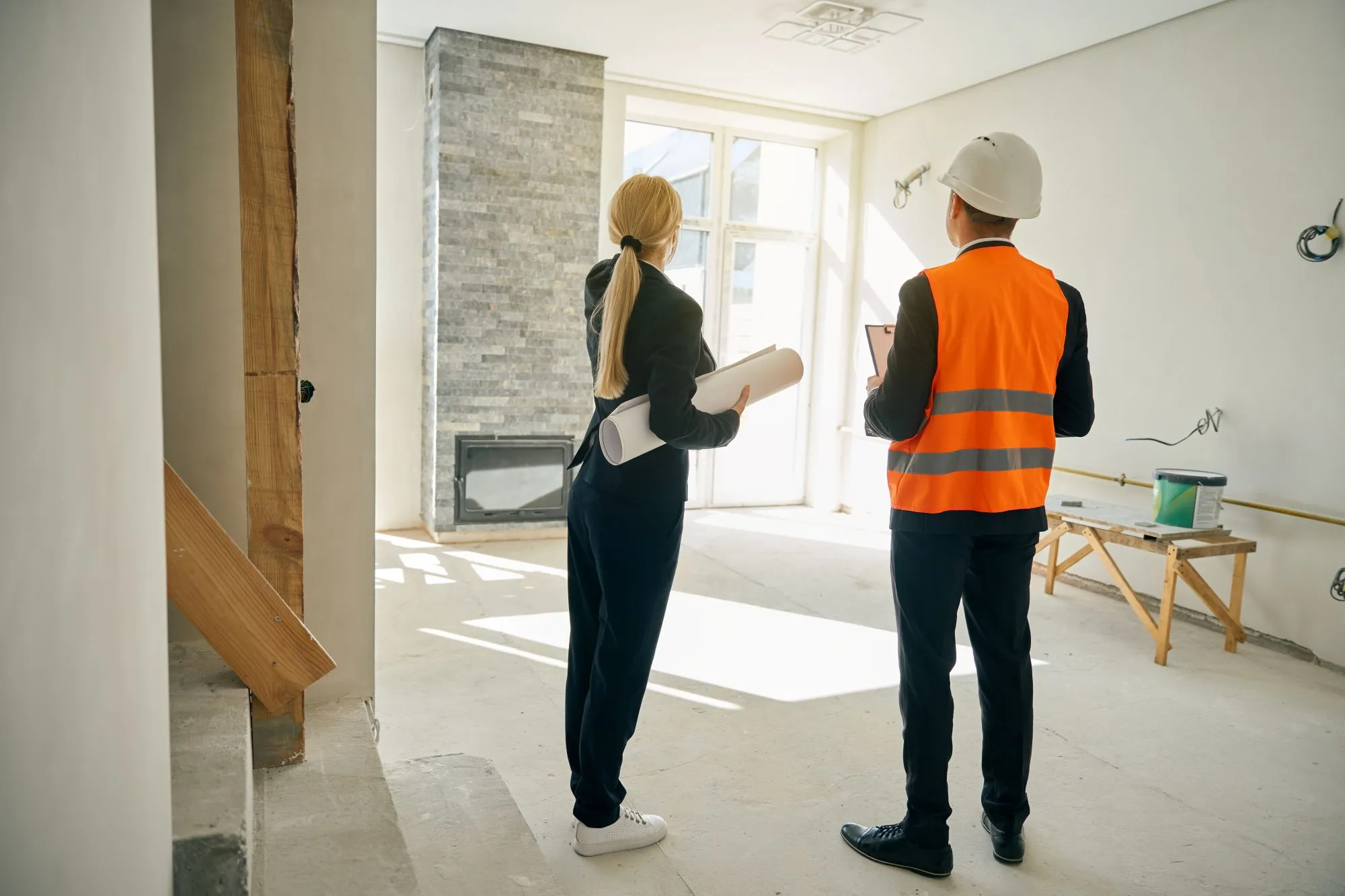 construction site with workers adjusting plans showing cost and delay impact from design changes